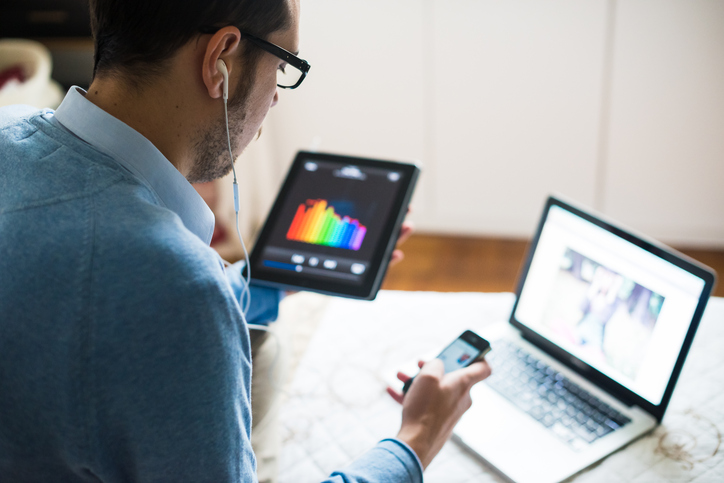 elegant business multitasking multimedia man using devices at home